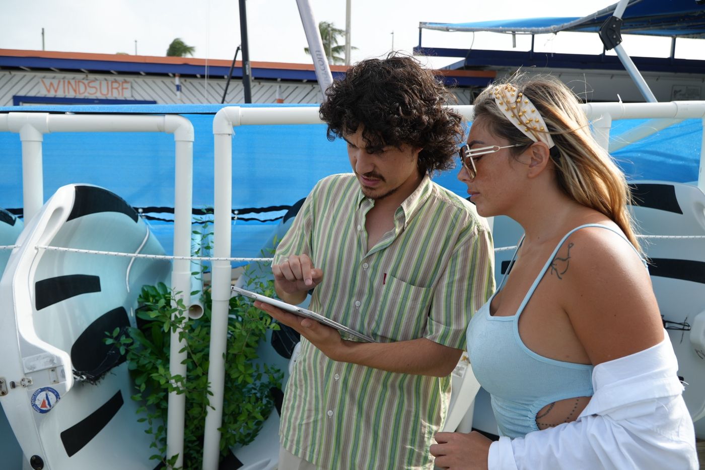 Director and crew member reviewing footage on a tablet at the boat dock